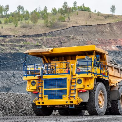 Large quarry dump truck. Transport industry. A mining truck is driving along a mountain road. Quarry truck carries coal mined.